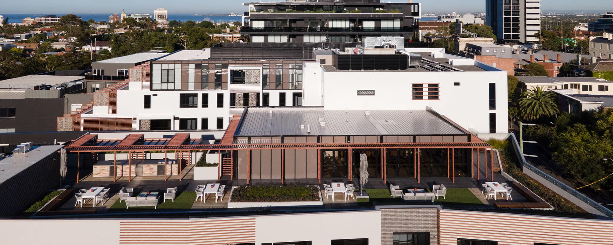 Drone view of europa building rooftop with bbq and seating